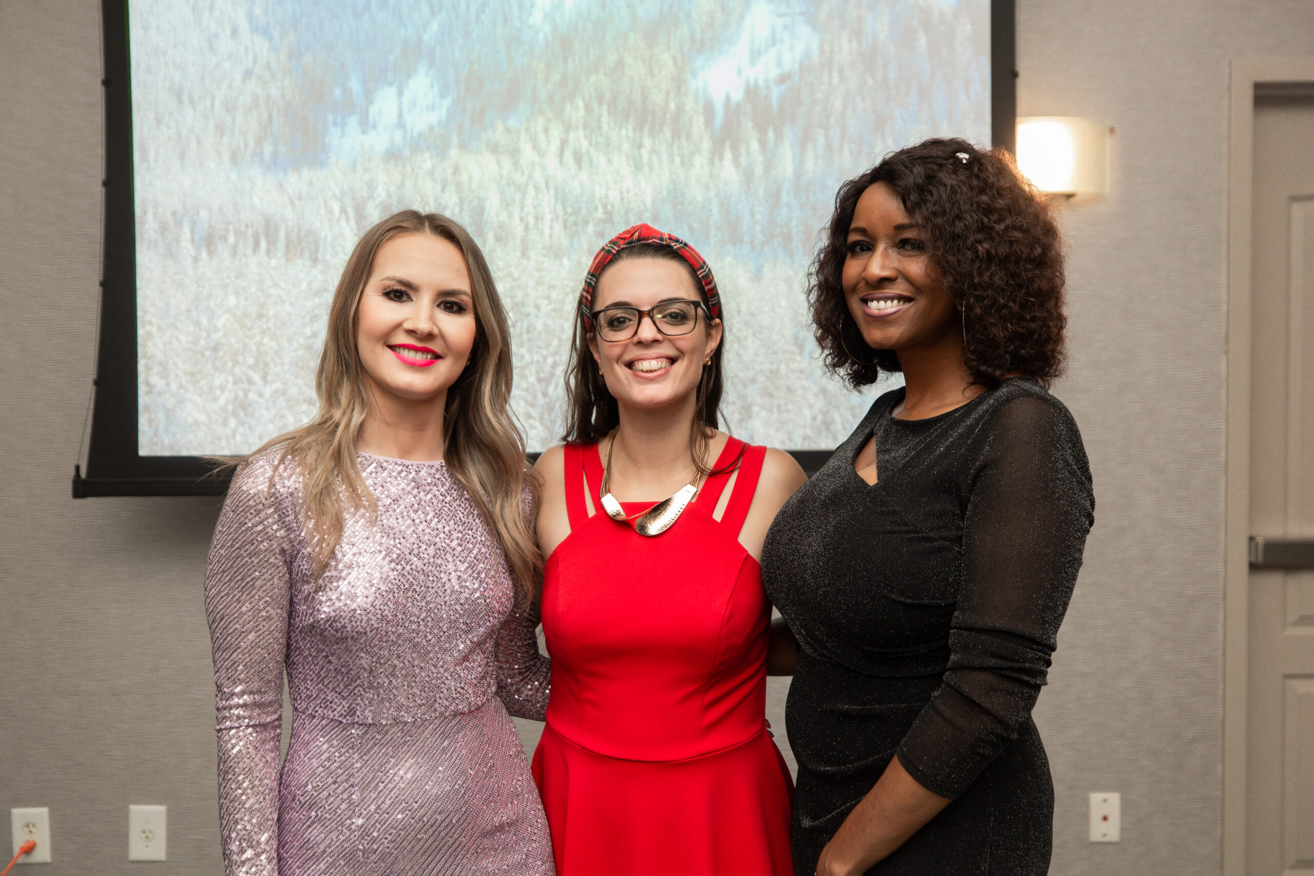 Realtor Nadya Lopes , Web Designer Solange Edwards and Director of Public Relations Latoya Grayson glistening with Christmas colors
